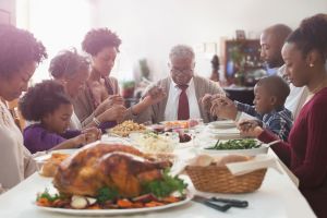 Family saying grace at holiday table