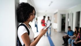 Side view of a student using smartphone during break time at school