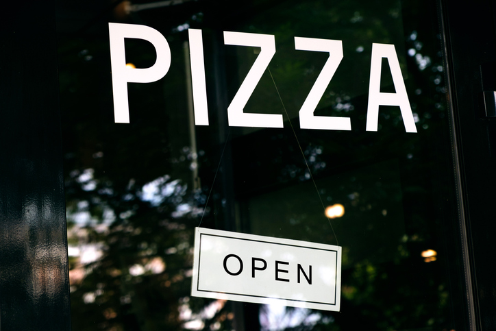 The Glass Doors Of The Pizzeria, Cafe With The Inscription Are Open. Removal of pandemic and quarantine restrictions. The concept of fast food.