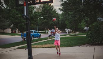 Girl Attempting to Throw a basketball through a hoop
