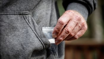 fentanyl heroin opiate in plastic bag in hand close-up in pocket