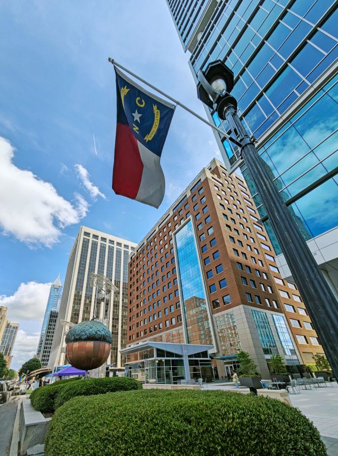 View of the skyline along Fayetteville Street in downtown Raleigh North Carolina with the NC State flag in the foreground